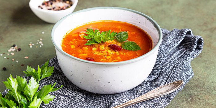 a bowl of homemade red bean and lentil soup, bread and parsley on stone background vegetable spicy soup selective focus