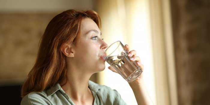 woman drinking water from glass at home