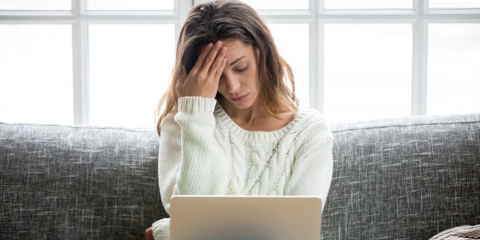 frustrated sad woman feeling tired worried about problem sitting on sofa with laptop, stressed depressed girl troubled wi...