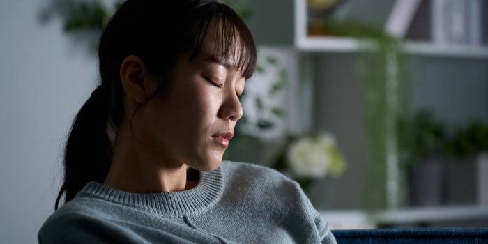 woman closing her eyes in a dark room