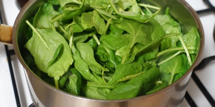 baby spinach in a saucepan for boiling