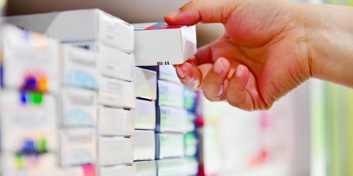closeup pharmacist hand holding medicine box in pharmacy drugstore