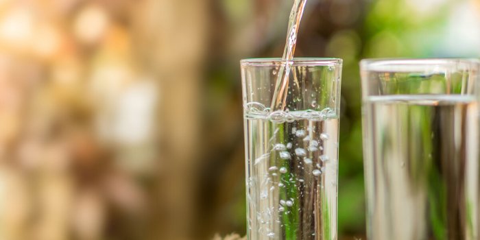 pouring fresh water on drinking glass over nature sunlight morning ,freshness concept background