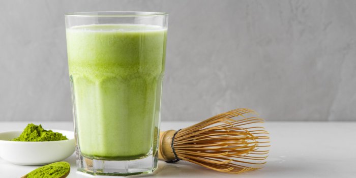 matcha green tea iced latte with matcha powder and bamboo whisk cold refreshment summer drink vegan food