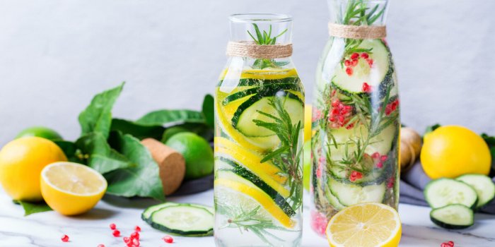 health care, fitness, healthy nutrition diet concept fresh cool lemon cucumber rosemary pomegranate infused water, detox ...