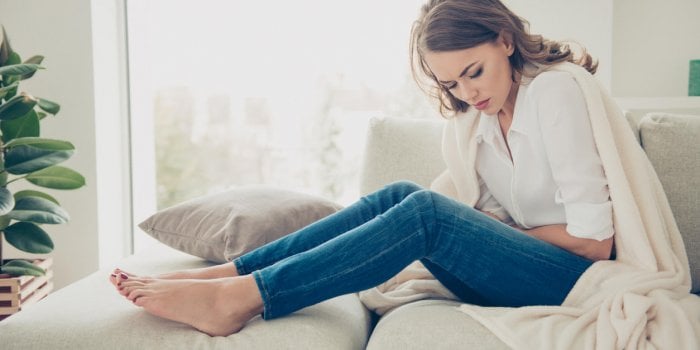 sad, upset, unhappy woman holding hands on stomach suffering from abdominal pain with close eyes, having menstrual period...