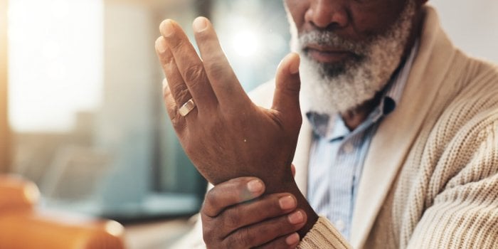 home, hands and senior black man with wrist pain for injury, inflammation and discomfort of carpal tunnel house, male per...