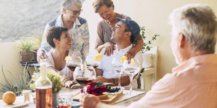 happy group of friends outdoor celebrating and having fun together during a dinner in the terrace at home laughs and smil...