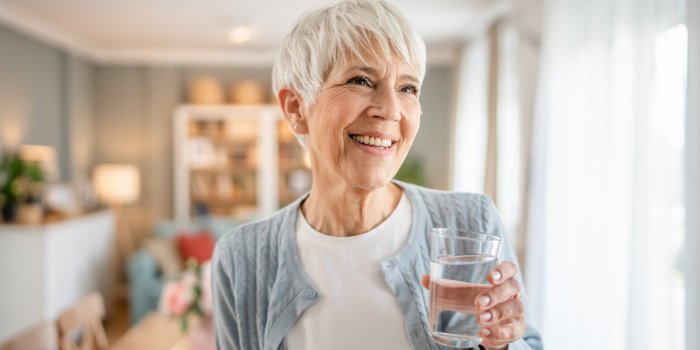 close up portrait of one senior woman with short hair happy smile positive emotion copy space standing at home indoor gra...