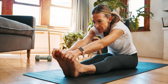 senior woman, stretching and exercise in living room for fitness, cardio and wellness on yoga mat home training retiremen...