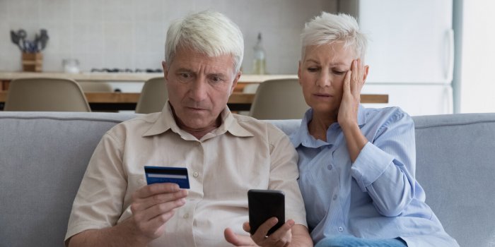 shocked aged couple become victims of online fraud using credit card phone to pay for goods order service online on suspi...