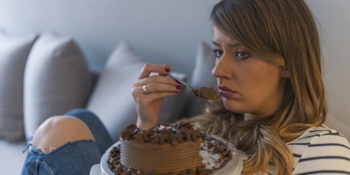 depressed woman eats cake sad unhappy woman eating cake sad woman eating sweet cake close up of woman eating chocolate ca...