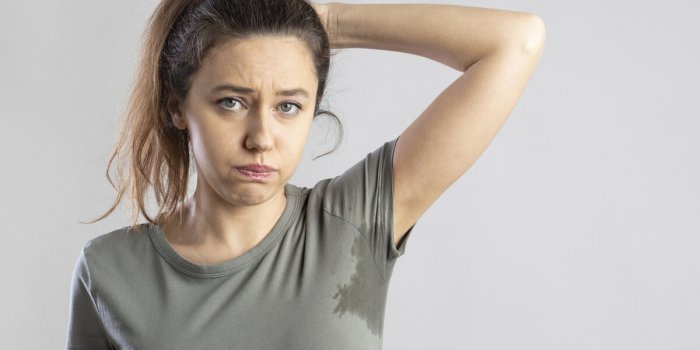 excessive sweating problems young woman with her arm raised with her armpits sweat