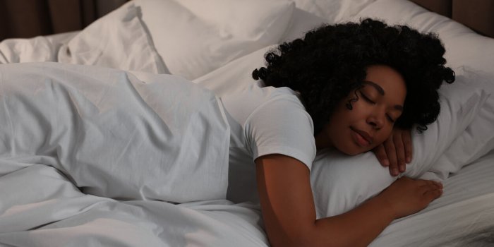 young woman sleeping in soft bed at night