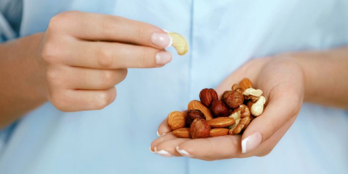 close up of nuts in woman hands female holding healthy snacks healthy lifestyle nutrition and diet high quality image